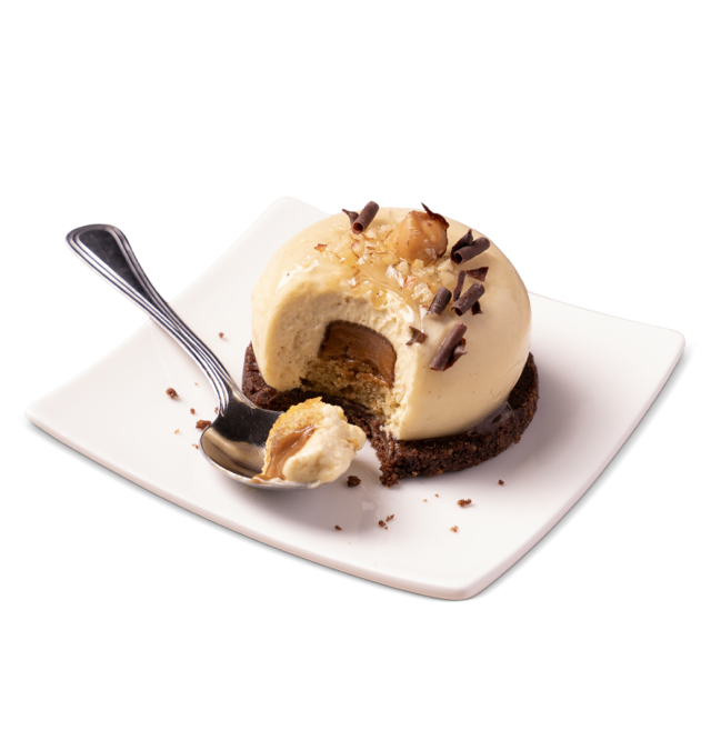 Sobremesa em cúpula de mousse de caramelo sobre base de bolacha de chocolate, com avelãs e raspas de chocolate, com u...