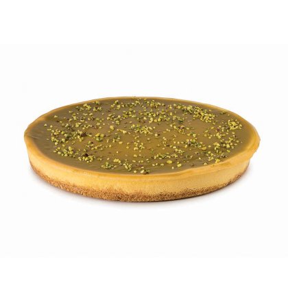 Tarte redonda com glaceado de caramelo liso, base tipo bolacha e pistácio triturado por cima.