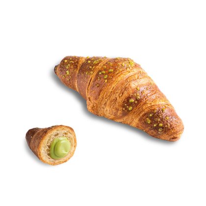 Croissant dourado coberto com pedaços de pistácio, com um pedaço mais pequeno aberto a revelar creme verde de pistácio.