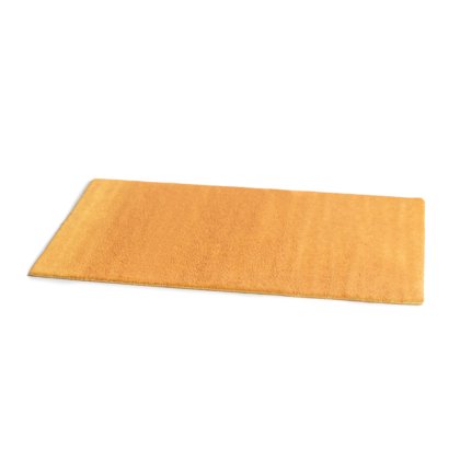 Tapete retangular amarelo-mostarda de pelo espesso, mostrado em ângulo sobre fundo branco.