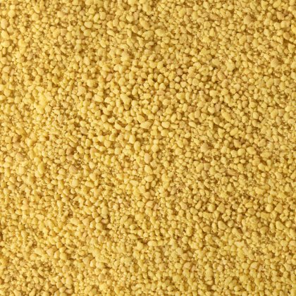 Plano aproximado de textura granulada fina e amarela, semelhante a farinha de milho grossa ou grãos de cuscuz seco, c...