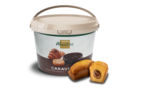 Balde grande de creme para barrar Master Martini Caravella ao lado de um mini bolo com creme de chocolate.