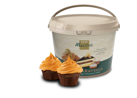 Balde bege de creme para barrar Master Martini com dois cupcakes de chocolate cobertos com cobertura laranja à frente.