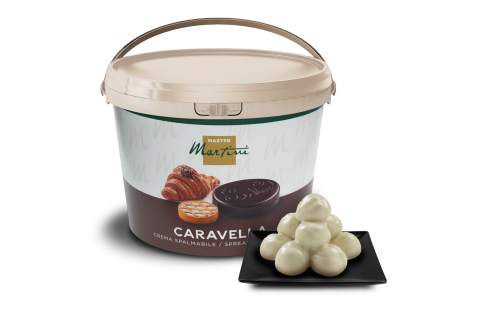 Embalagem grande de creme para barrar Master Martini Caravella ao lado de trufas de chocolate branco num prato quadra...