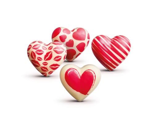 Quatro chocolates brancos em formato de coração decorados com marcas de beijo vermelhas, corações, riscas e um coraçã...