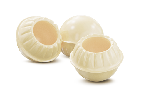 Três cascas redondas de chocolate branco com bordas onduladas, duas ocas, em fundo branco.